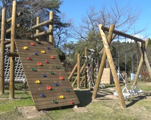 六甲GREENIA運動公園的戶外攀岩牆與繩網遊樂區，提供兒童與成人挑戰體能，背景為開闊的自然環境。