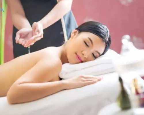 A professional therapist at Viva Jiva Spa in Bangkok performs a Thai oil massage on a client, providing deep relaxation and renewed vitality with gentle techniques.
