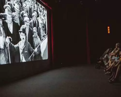 Khách tham quan tại bảo tàng Chaplin's World ở Vevey thưởng thức một bộ phim đen trắng kinh điển của Charlie Chaplin trong phòng chiếu nhập vai, trải nghiệm ma thuật điện ảnh của bậc thầy.