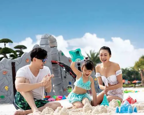一家人在珠海長隆橫琴灣水世界的「海灘花園」玩樂，孩子們堆沙堡，父母陪伴，享受陽光下的家庭時光。