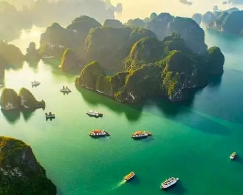Breathtaking panoramic view of Halong Bay at sunset or sunrise, showcasing its numerous limestone karsts and emerald waters, a New Seven Wonders of Nature.