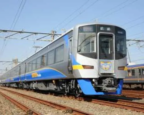 A sleek silver train with blue and yellow accents on the tracks, offering comfortable and efficient rail travel across Tokushima prefecture, included with the 5-day Nankai Tokushima Free Pass.