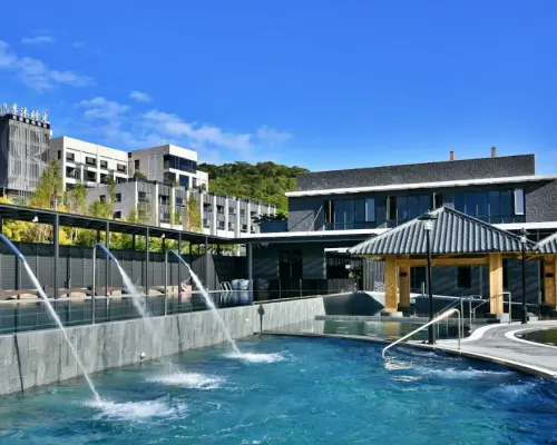 苗栗享沐時光莊園渡假酒店戶外露天溫泉區，多個特色溫泉池與水療設施，搭配藍天及壯麗建築景觀，提供極致放鬆的泡湯享受。