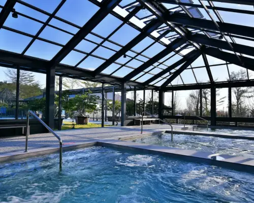 享沐時光莊園渡假酒店採光極佳的室內溫泉池，玻璃屋頂與大面窗戶設計，讓泡湯者在綠意環繞中享受溫暖水流與自然光。