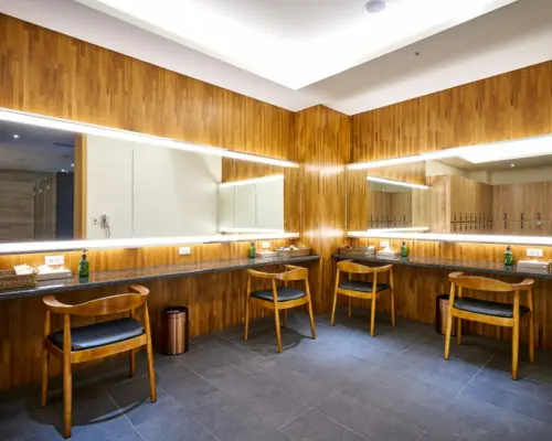 苗栗享沐時光莊園渡假酒店設計時尚的更衣梳妝區，設有寬敞明亮的鏡面、獨立座位與洗手台，提供泡湯前後的舒適準備空間。