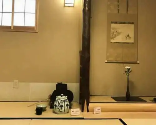A serene corner of a traditional Tokyo tea room, beautifully arranged with exquisite tea ceremony utensils and a hanging scroll, creating an elegant ambiance for the upcoming tea ceremony experience.