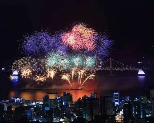 從高處鳥瞰釜山廣安里，2025釜山煙火節點亮廣安大橋與城市夜景，呈現壯麗煙火秀。