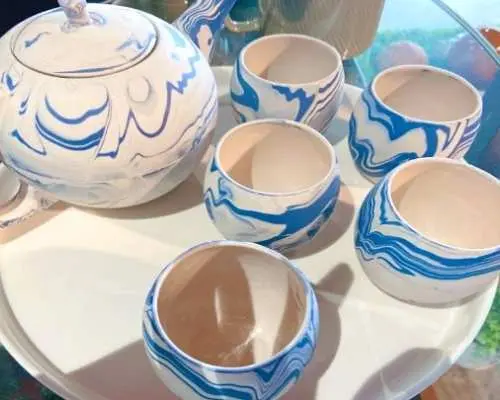 ベトナムのバッチャン村で作られた、白と青の大理石模様が美しいティーポットと matching のカップセットがクローズアップで映されています。