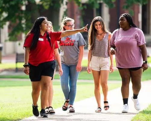 Diverse students interacting on a Korean university campus path, creating a relaxed and joyful learning atmosphere for study tour participants, fostering a deeper understanding of the education system.