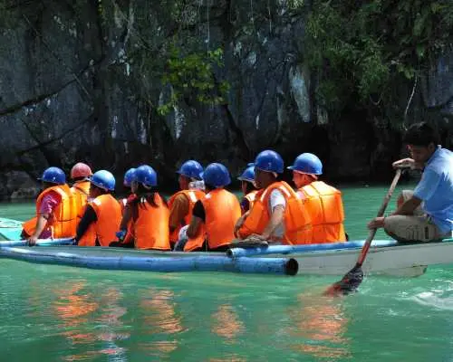 กลุ่มนักท่องเที่ยวสวมเสื้อชูชีพ พร้อมไกด์พายเรือ เตรียมออกเดินทางสำรวจอุทยานแห่งชาติแม่น้ำใต้ดินปูเอร์โตปรินเซซา ปาลาวัน ฟิลิปปินส์
