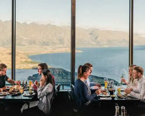 Diners savor a delicious buffet with unparalleled floor-to-ceiling views of Queenstown and Lake Wakatipu from the Skyline Gondola restaurant.