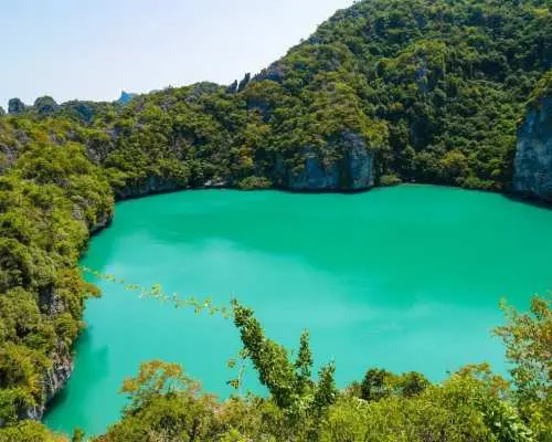 The iconic Emerald Lake (Talay Nai) within Angthong National Marine Park in Koh Samui, a stunning emerald green lagoon encircled by verdant limestone cliffs, offering a picturesque view.