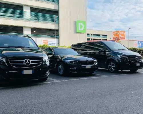 埃因霍温机场私人接送车队，三辆黑色奔驰豪华休旅车与轿车停在停车场，提供多样化选择。