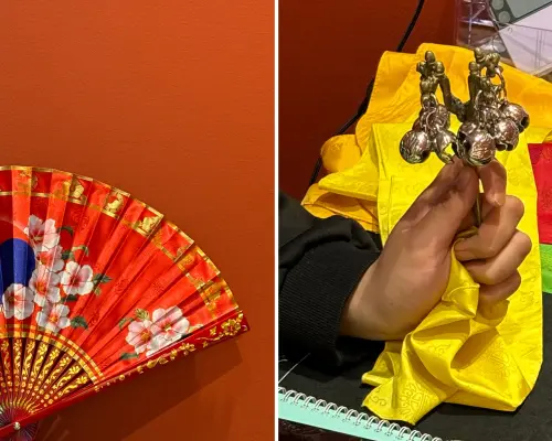 Authentic scene from a Seoul fortune-telling experience, featuring a traditional red floral fan and a shaman holding brass bells, symbolizing Korean spiritual practices.