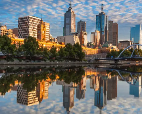 壮丽的墨尔本城市天际线在雅拉河上完美倒影，高楼大厦与桥梁在清晨阳光下熠熠生辉，呈现城市之美。