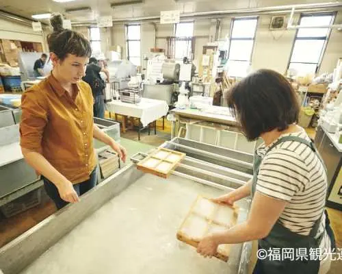 親身體驗八女和紙製作，遊客在工作人員指導下，使用傳統木框將紙漿撈起，學習日本傳統造紙技藝。