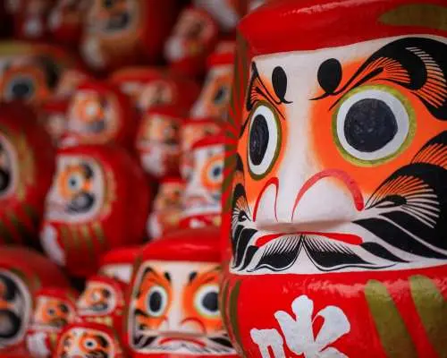 Thousands of vibrant red Daruma dolls stacked at Katsuo-ji Temple in Osaka, symbolizing victory, good luck, and perseverance for visitors.