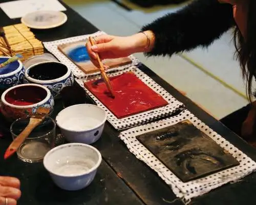 浮世繪版畫製作體驗中，參與者專注將顏料塗抹於獨家版木上，準備在和紙上印刷，感受傳統工藝。