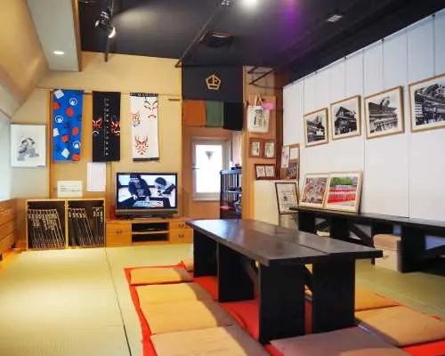 上方浮世繪館內舒適的日式休息區，榻榻米、低矮木桌與浮世繪作品展示，提供學習與休憩空間。