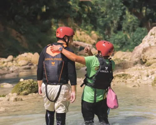 LOKALPAGE专业导游在宿雾卡瓦山峡谷探险中，细心指导并陪伴穿戴装备的游客，确保安全。