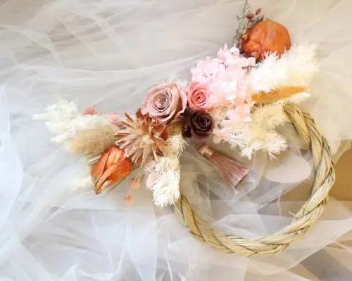 An exquisite preserved flower wreath, a creative option from Myosotis.flower Kwun Tong DIY workshop, featuring a woven vine base adorned with pink preserved roses and dried floral materials.