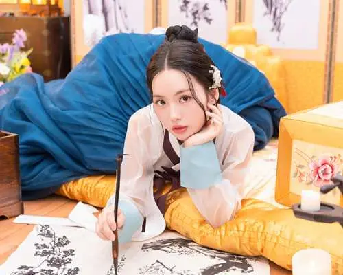 A woman in a traditional Hanbok gracefully engaging in calligraphy indoors, showcasing the immersive cultural experience of a Seoul Hanbok photoshoot.