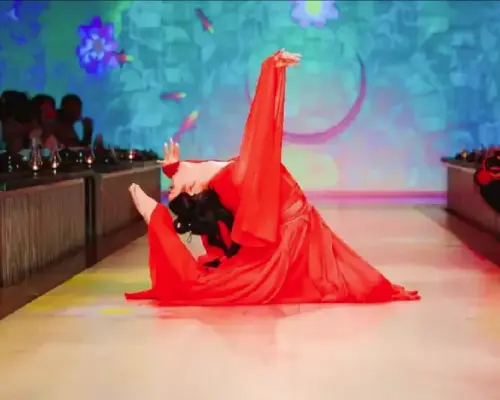 A dancer in a vibrant red Hanfu performs classical dance on an immersive digital light and shadow stage at the Beijing Palace Banquet, offering an imperial audio-visual feast.