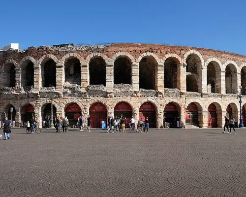 Spectacular daytime exterior of the Verona Arena, showcasing the grand architecture of the ancient Roman amphitheater under clear skies, offering free entry with the Verona Card.