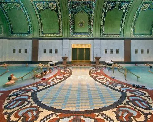 蓋勒特溫泉浴場奢華的室內溫泉池，綠色拱頂與彩繪瓷磚裝飾精美，展現布達佩斯歷史悠久的溫泉建築藝術。