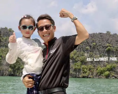 랑카위 킬림 지오포레스트 공원에서 아버지와 딸이 스피드보트를 타고 즐겁게 사진을 찍고 있으며, 랜드마크를 배경으로 가족 맹그로브 탐험을 즐깁니다.