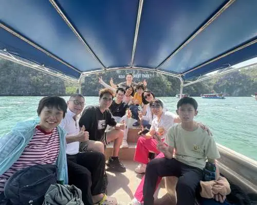 랑카위 지오포레스트 공원 맹그로브 수역에서 관광객들이 스피드보트를 타고 즐겁게 기념사진을 찍으며, 햇살과 자연 경관을 만끽하며 반일 투어를 즐깁니다.