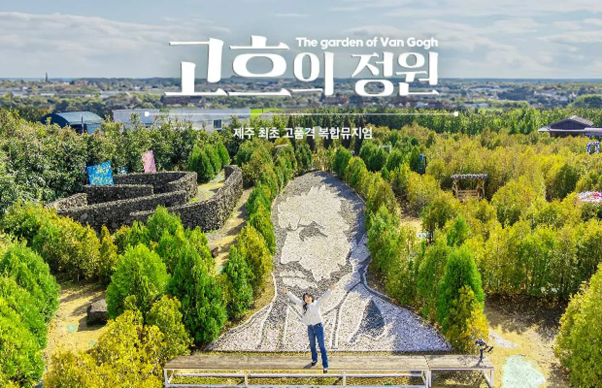 제주 반고흐 정원의 항공 사진. 울창한 녹음과 경치를 감상하는 방문객들로 둘러싸인 거대한 반 고흐 초상화 조경 예술 작품을 보여줍니다.