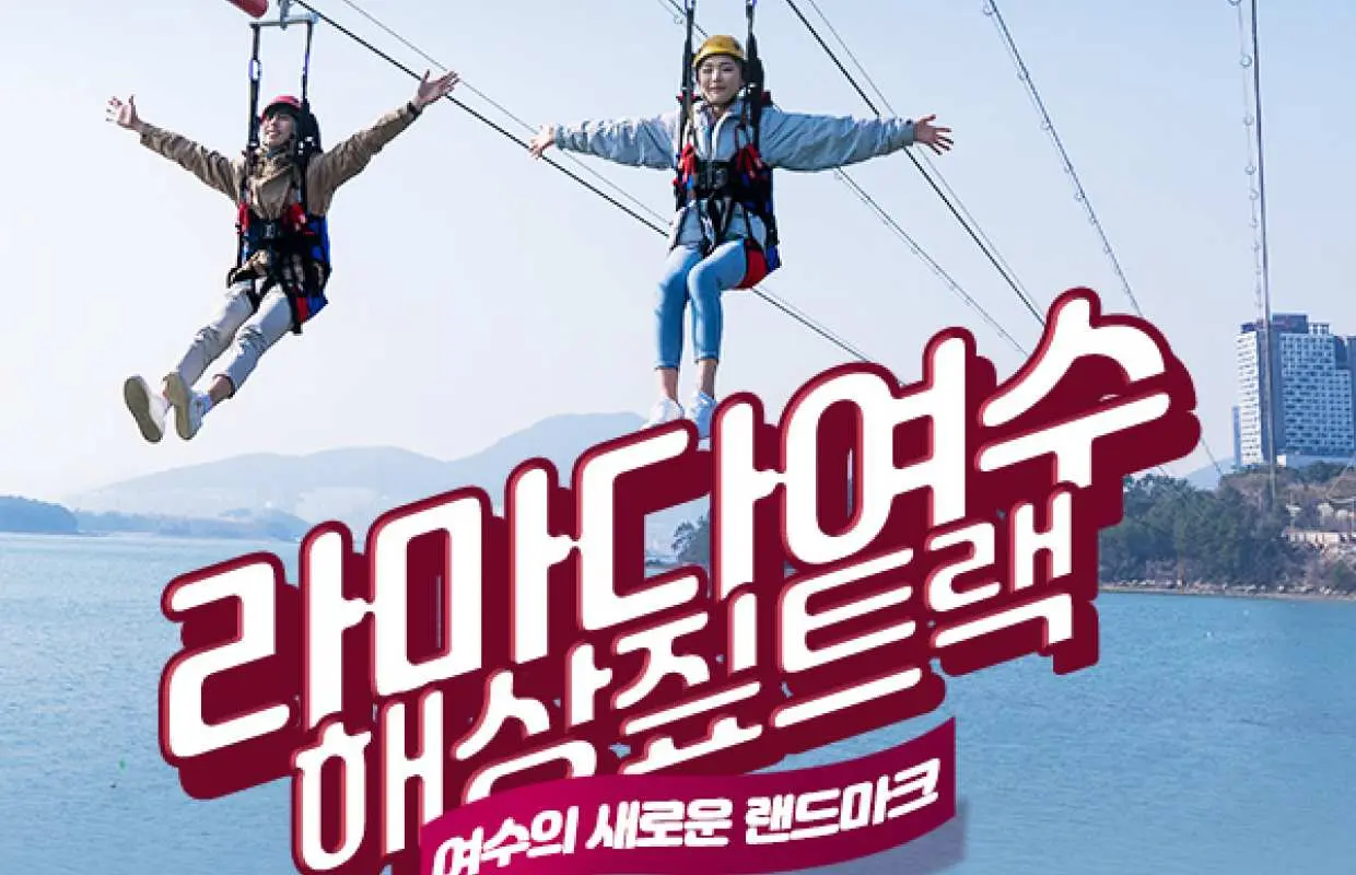 한국 여수 라마다 해상 짚트랙에서 멋진 바다와 호텔을 배경으로 두 명의 방문객이 하늘을 날며 스릴 넘치는 고공 체험을 즐기고 있습니다.