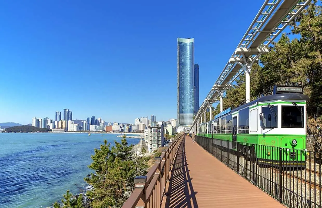 Cheongsapo Blue Line Park Beach Train travels along coastal tracks, offering views of Busan's high-rise buildings and the beautiful blue coastline, part of the 2023 Korea Tourism Star experience.