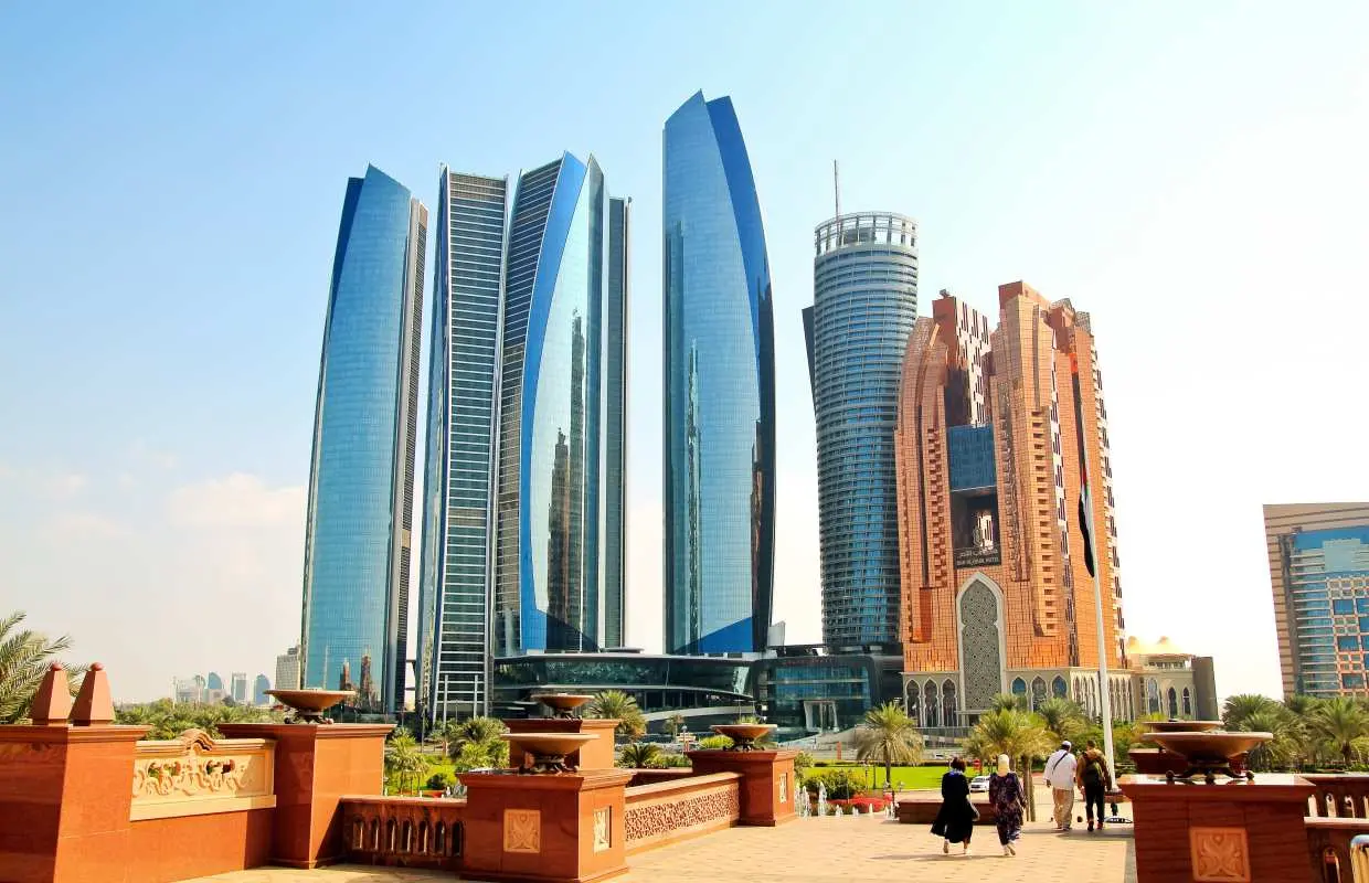 阿布扎比市区雄伟的阿提哈德塔群，其独特现代建筑与周边绿地构成天际线，象征着城市的繁荣与魅力。