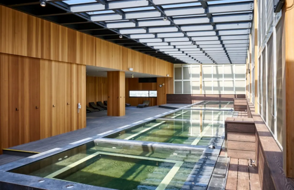 苗栗享沐時光莊園渡假酒店寬敞明亮的室內溫泉設施，設有多個溫泉池和木質休憩區，透過透明屋頂引入自然光線，營造舒適泡湯體驗。