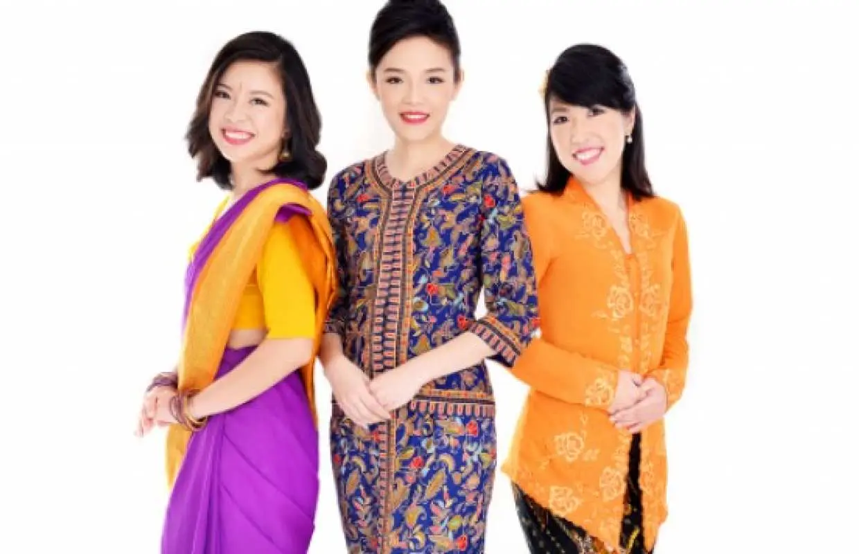 シンガポールでの伝統衣装体験で、シンガポール航空のCA制服、クバヤ、サリーを着用した3人の女性が笑顔でプロの撮影を受けている様子。