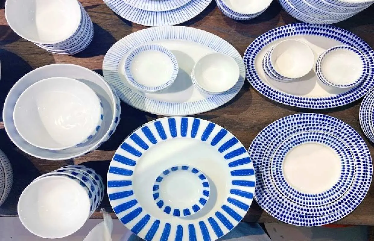 ベトナムのバッチャン村で作られた、青と白の美しい模様が特徴の伝統的な陶器の皿とボウルが並べられています。