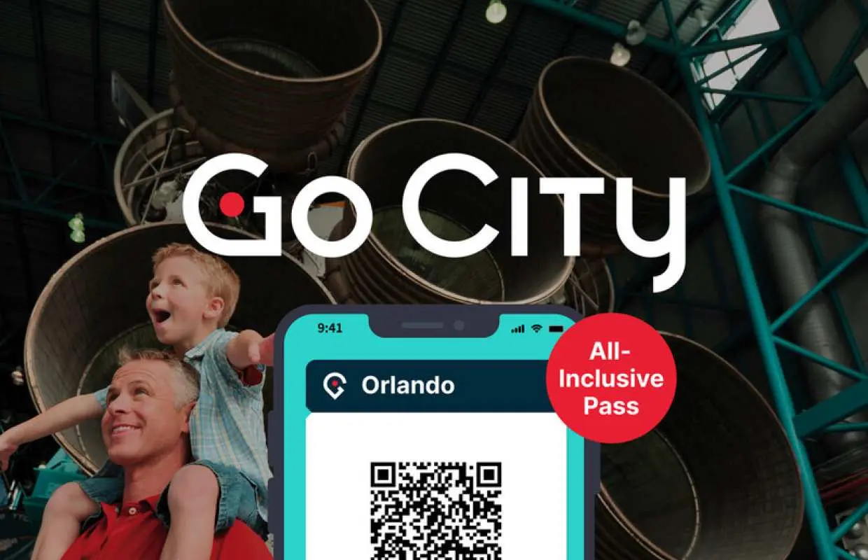 Father and son excitedly exploring Kennedy Space Center, with a digital Go City Orlando All-Inclusive Pass on a smartphone screen, highlighting easy entry to top attractions.