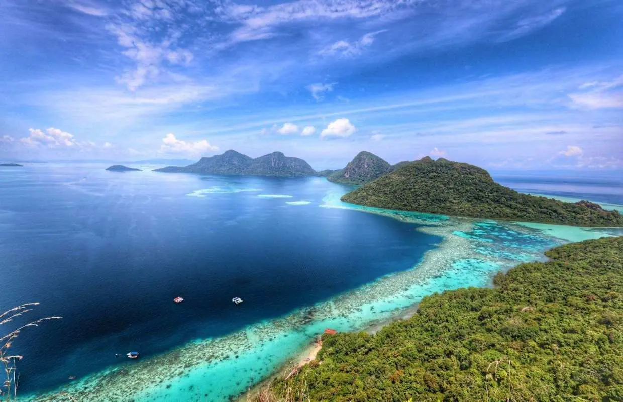 Breathtaking panoramic view of Tun Sakaran Marine Park from Bohey Dulang island peak, featuring Semporna's vibrant turquoise waters, lush islands, and coral reefs, ideal for hiking and snorkeling.