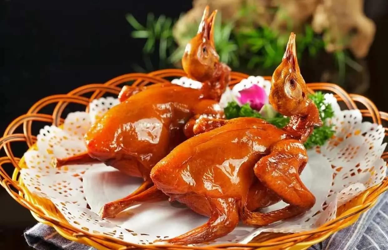 中山短線團特色美食【雀籠紅燒石岐乳鴿】特寫，金黃酥脆的乳鴿完美呈現，展現豐盛的團餐體驗。