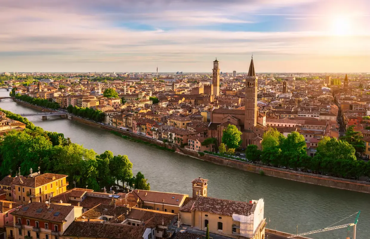 Panoramic Verona skyline at sunset over the Adige River, showcasing historic buildings and UNESCO World Heritage sites, easily explored with the Verona Card.