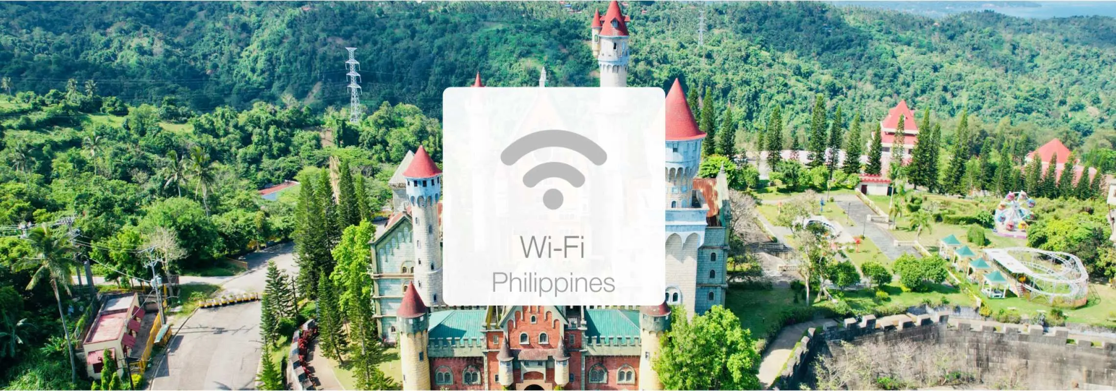 필리핀 푸른 산속의 성 같은 리조트 항공사진. 'Wi-Fi Philippines' 오버레이로 여행객을 위한 빠르고 안정적인 인터넷을 홍보합니다.