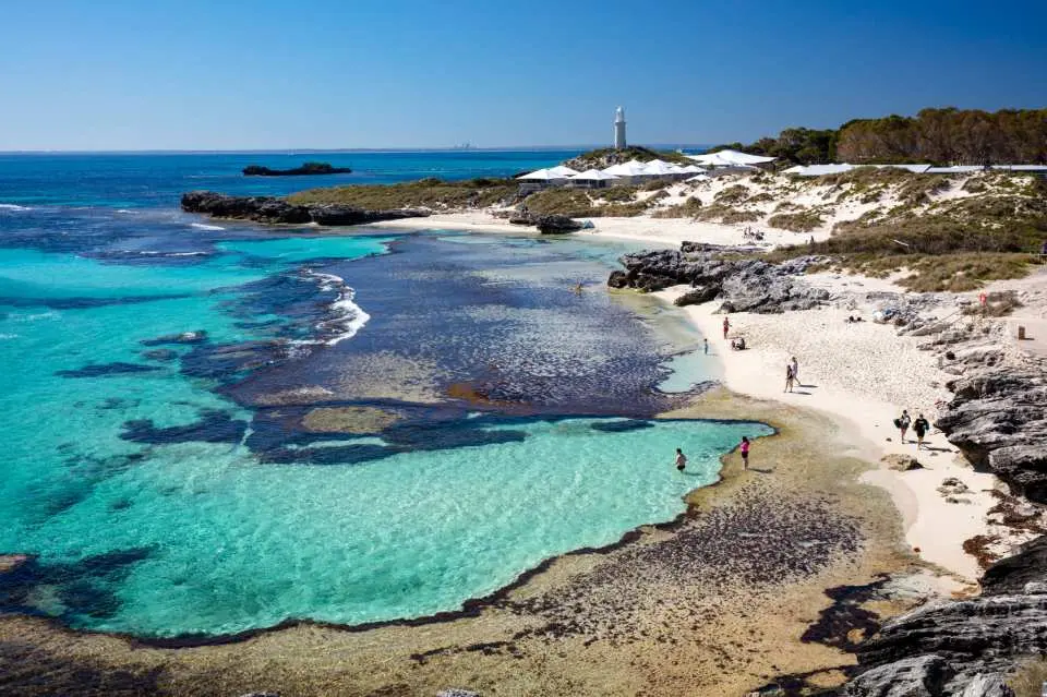 Bãi biển Rottnest Island Perth với làn nước xanh ngọc, bờ cát trắng và ngọn hải đăng ven biển