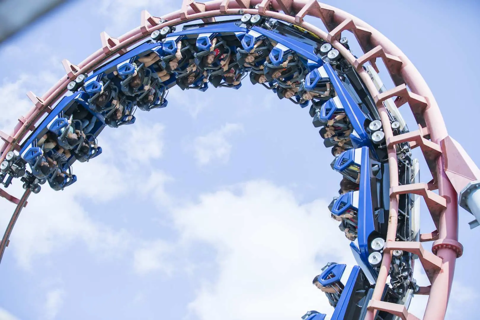 The Space Shuttle roller coaster at Enchanted Kingdom theme park in the Philippines, with blue cars rapidly inverting on red tracks, offering a thrilling experience.