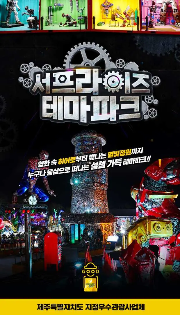 제주 서프라이즈 테마파크 야간 입구 전경. 거대한 로고와 스파이더맨 등 영화 캐릭터 폐기물 예술 작품들이 불을 밝히며 가족들을 이 독특한 테마파크로 초대합니다.