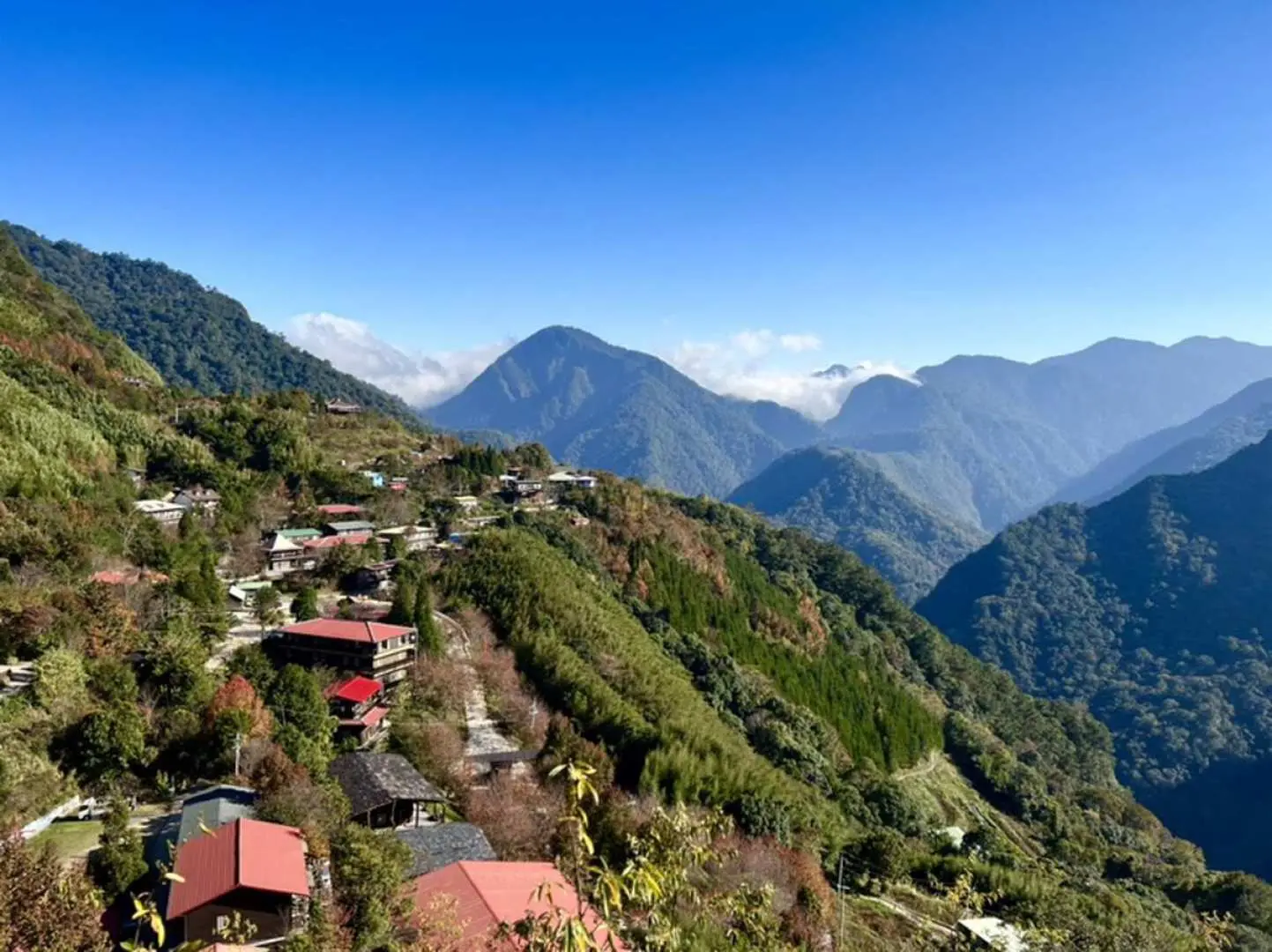 司馬庫斯部落高空俯瞰全景，錯落有致的房屋與層疊山巒、翠綠峽谷構成壯麗的「上帝的部落」風光。
