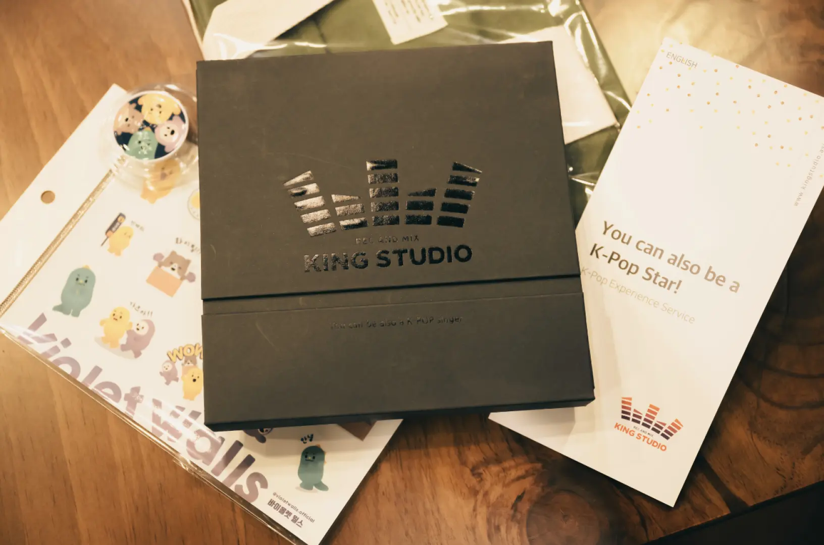 首爾King Studio韓流錄音體驗紀念品，包含印有工作室標誌的專輯盒、可愛貼紙和「您也可以成為韓流明星！」的卡片。