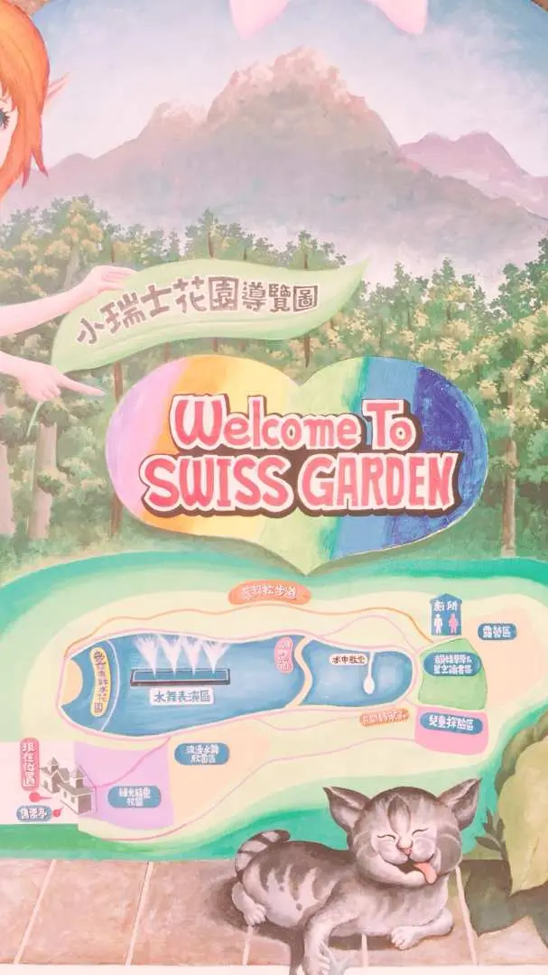 南投清境小瑞士花園的歡迎指示牌，標示「Welcome To SWISS GARDEN」並附園區地圖，下方有可愛的貓咪雕像。
