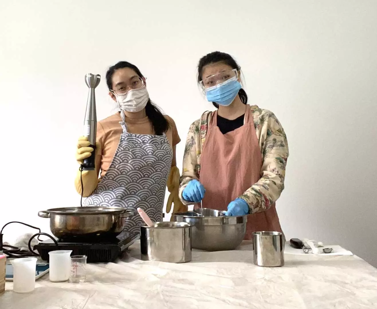 2 women posing for photo as they create soap